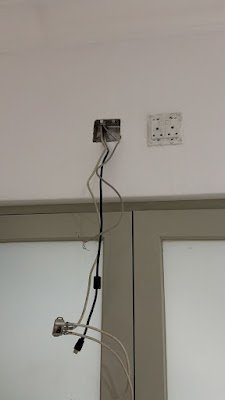 Loose socket and cable wiring above a cupboard before being secured into trunking